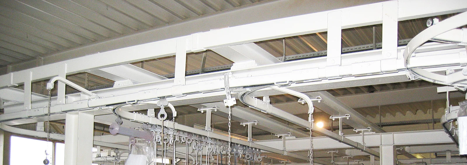 Handhängebahn in industrieller Fertigungshalle mit Laufschienen und Laufwerken